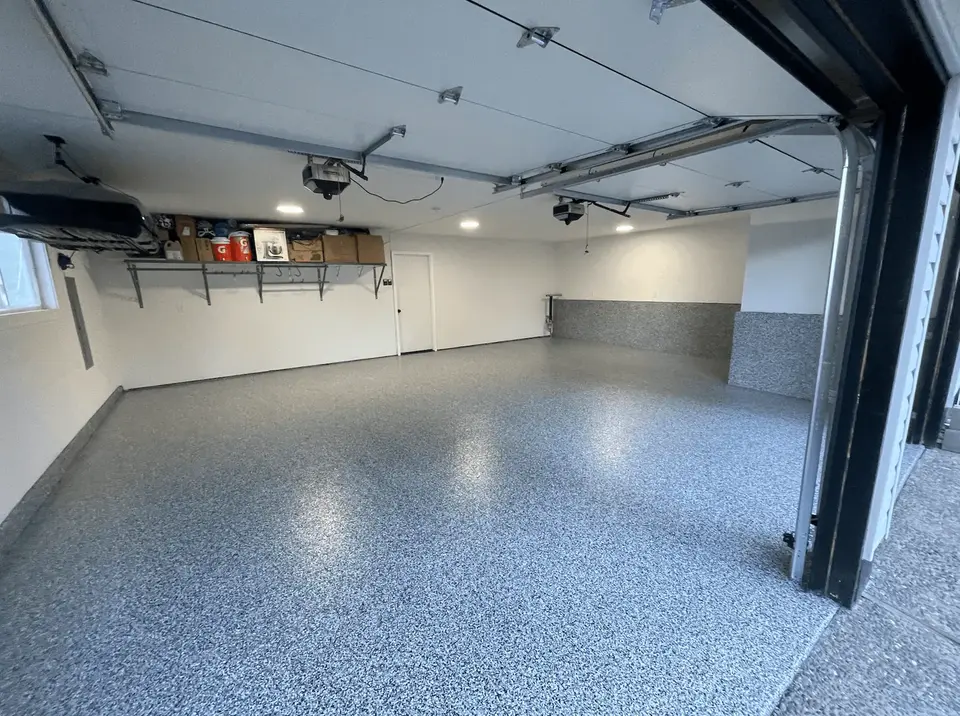 Finished garage with a blue granite flake floor coating and overhead storage racks