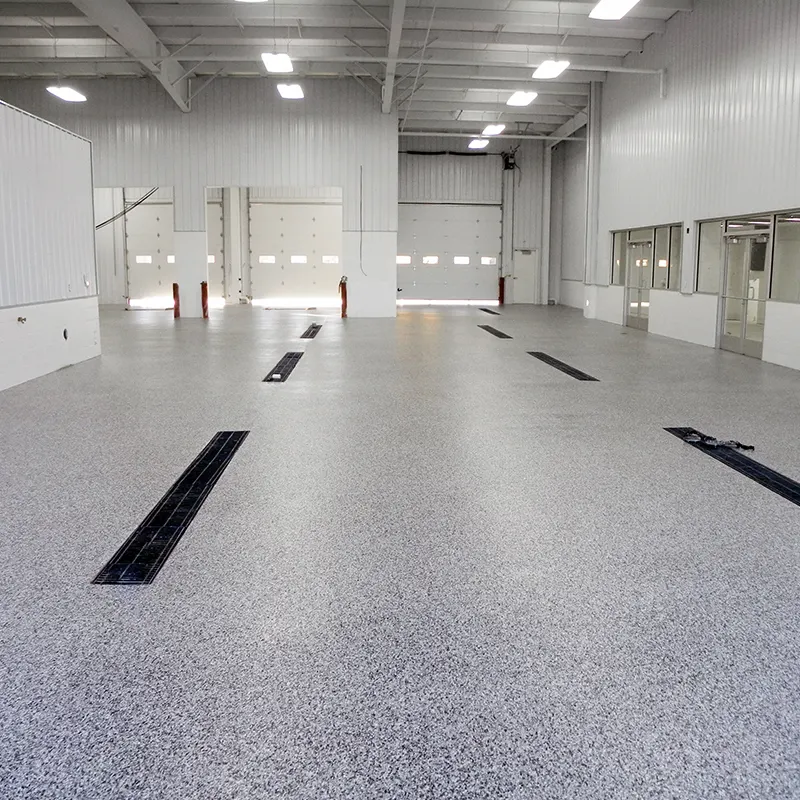 Multi-bay auto service shop with a light gray flake floor and trench drains
