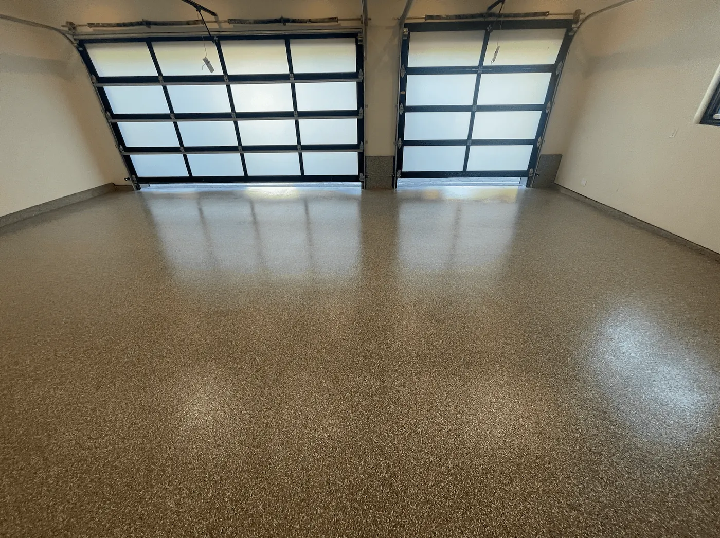 Seattle-area garage with a caramel flake floor and glass bay doors