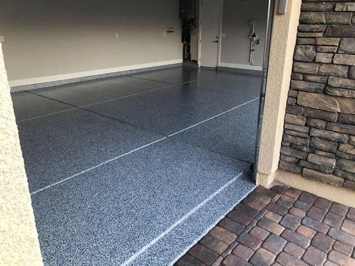 Blue-gray denim flake garage floor seen from the paver driveway