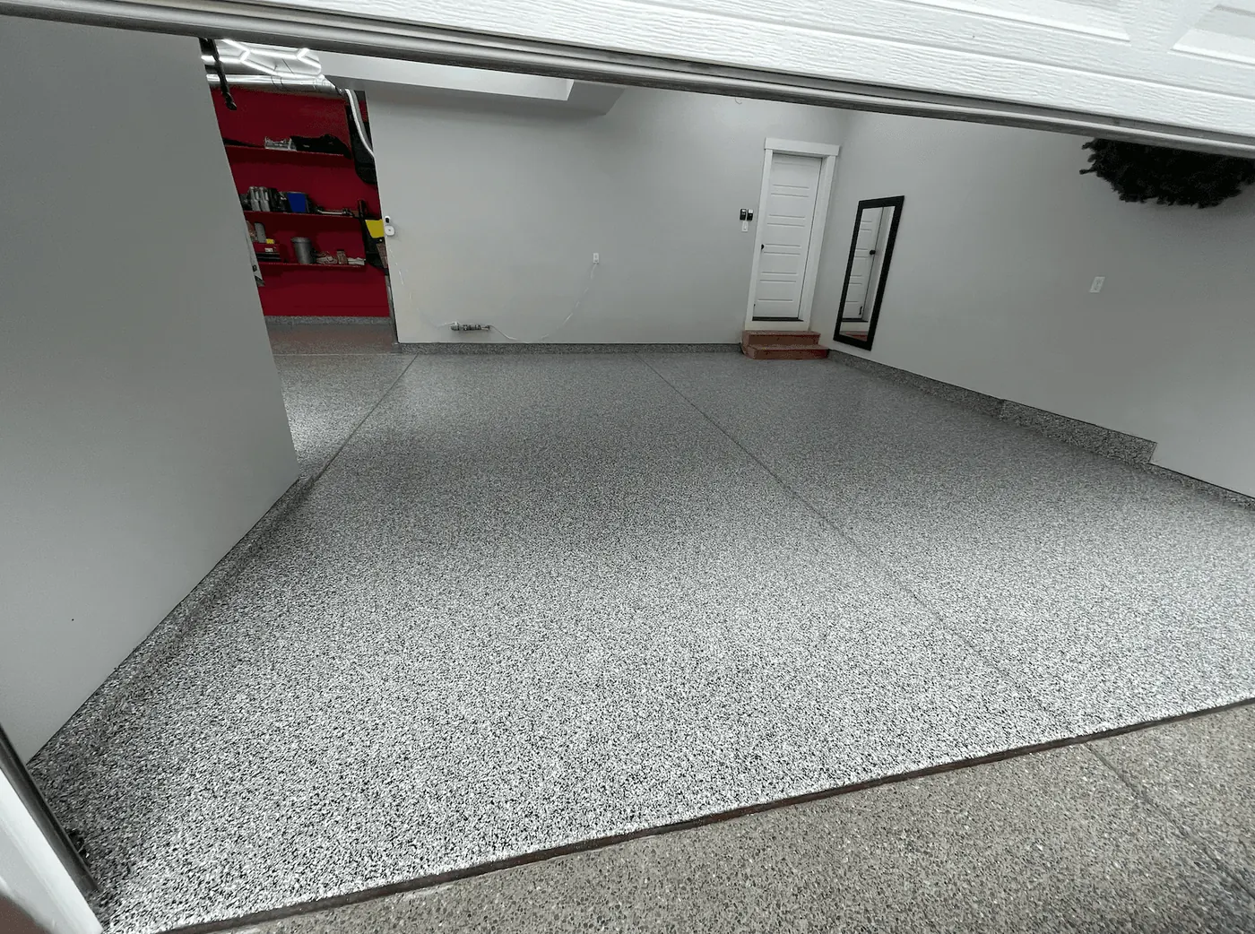 Storm gray flake floor running to a white wall and entry door in a Seattle-area garage