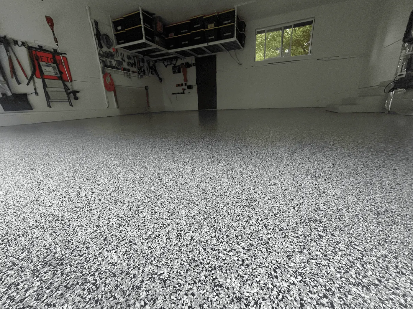 Home workshop with a silver flake floor and overhead storage