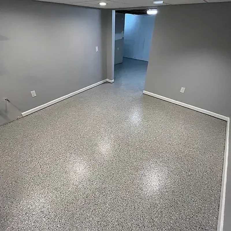Finished basement room with gray walls and a glossy gray flake floor
