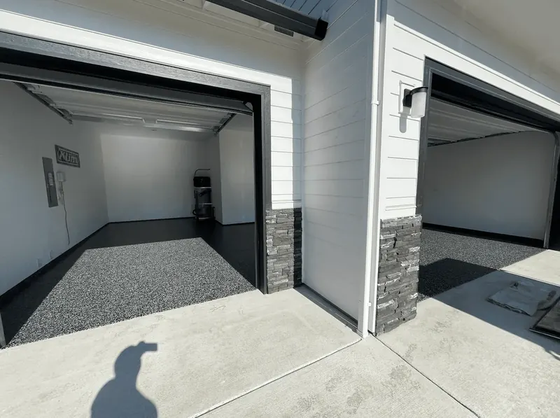 Charcoal flake floor inside a white Seattle-area garage, seen from the driveway