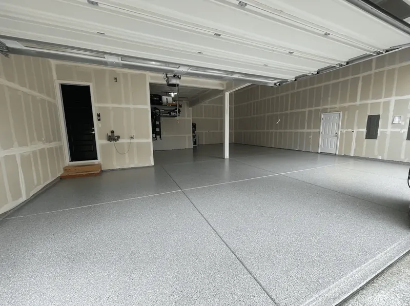 Wide dove gray flake floor in a Seattle-area garage, seen from beneath the raised door