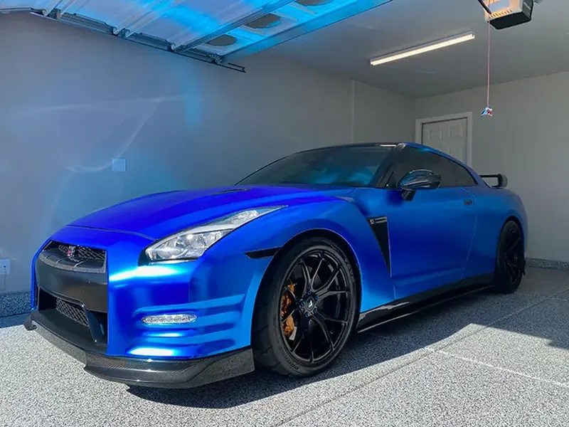Blue Nissan GT-R parked on a light gray flake garage floor