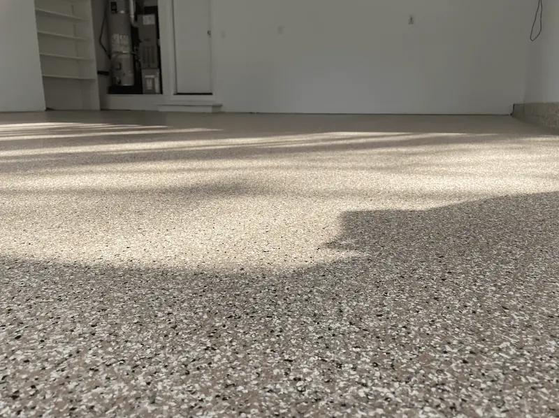 Low-angle close-up of sandstone flake texture on a Seattle-area garage floor