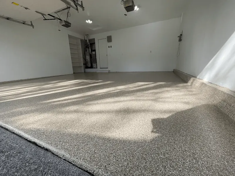 Sunlight and tree shadows across a sandstone flake floor in a Seattle-area garage