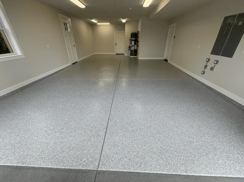 Silver flake floor in a long Seattle-area garage bay with a side window and electrical panel