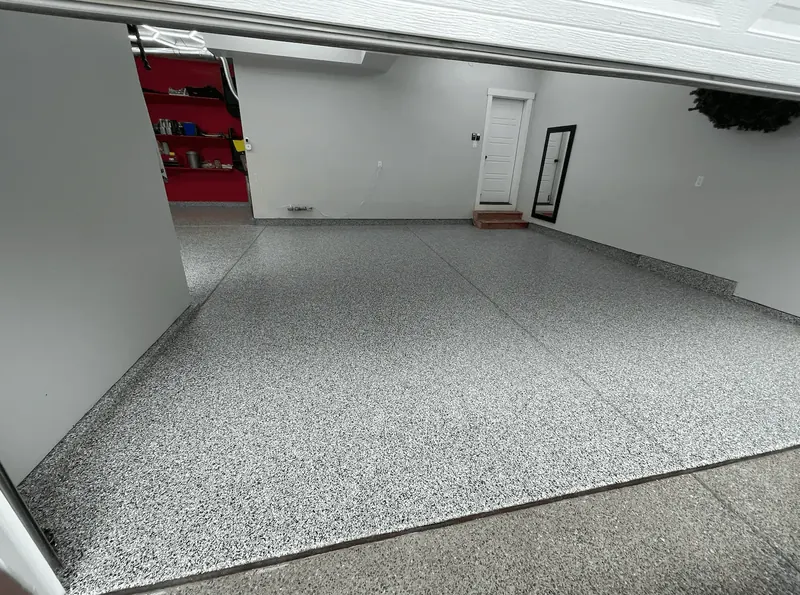 Storm gray flake floor running to a white wall and entry door in a Seattle-area garage