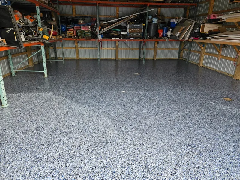 Pole-building workshop with a slate blue flake floor and loaded tool shelves