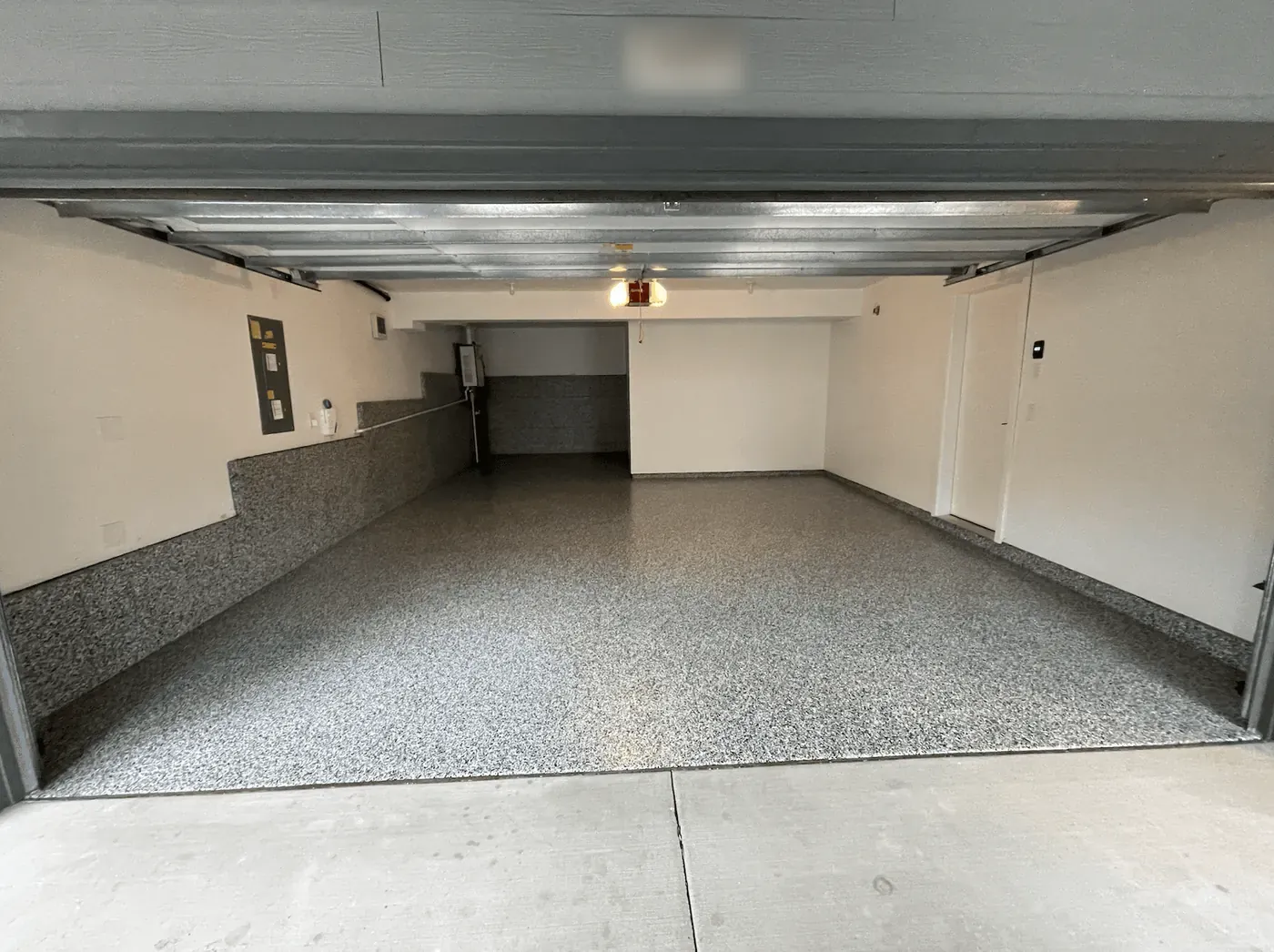 Pewter flake floor in a Seattle-area garage, seen from the driveway under the raised door