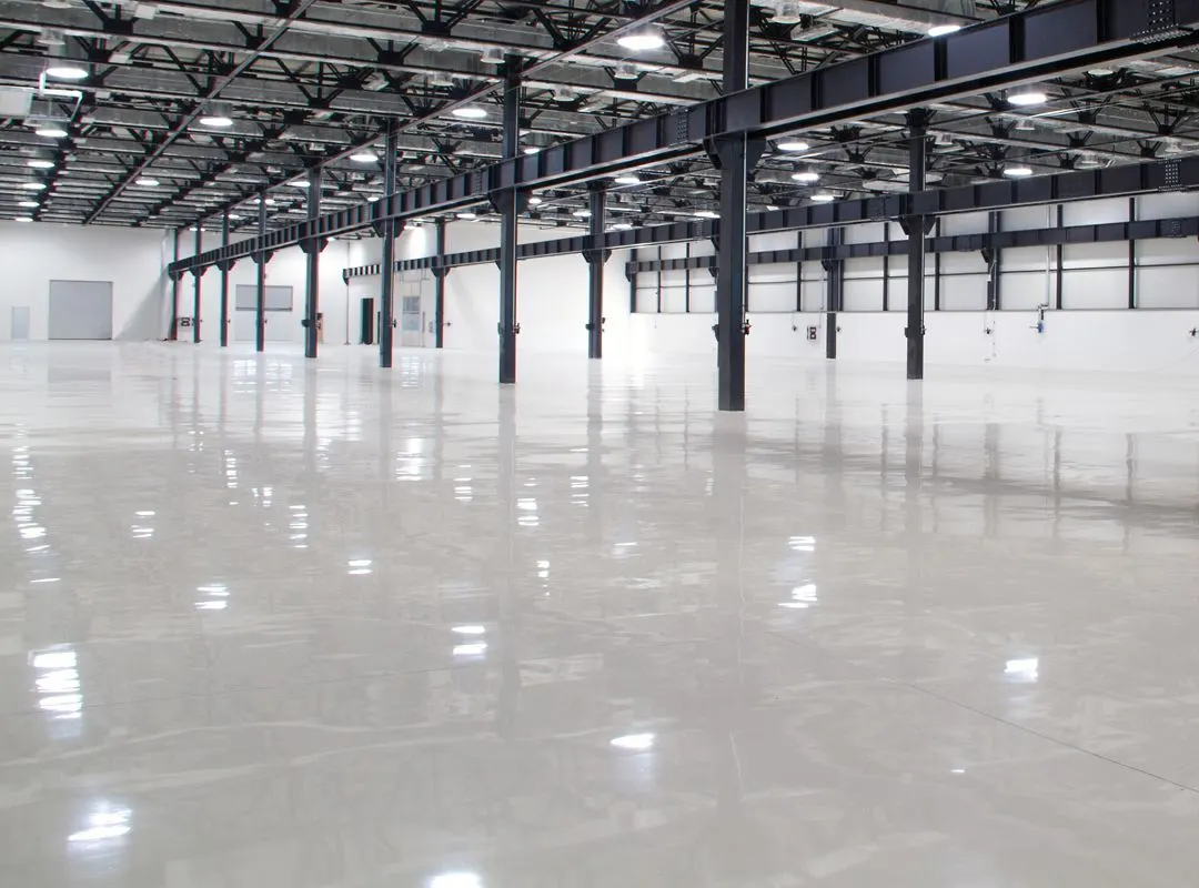 Large warehouse with black steel columns and a glossy light gray floor